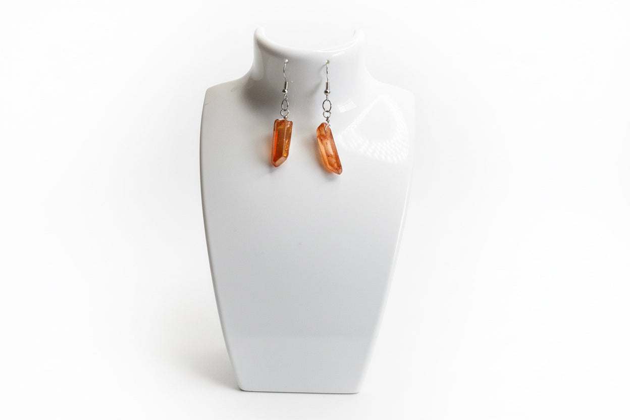 Amber drop peach 🍑 orange 🍊 earrings on a white bust against a white background